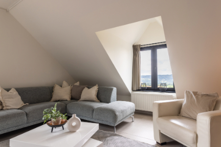 Loungehoek onder de schuine wanden met zicht op het balkon in EIK 9