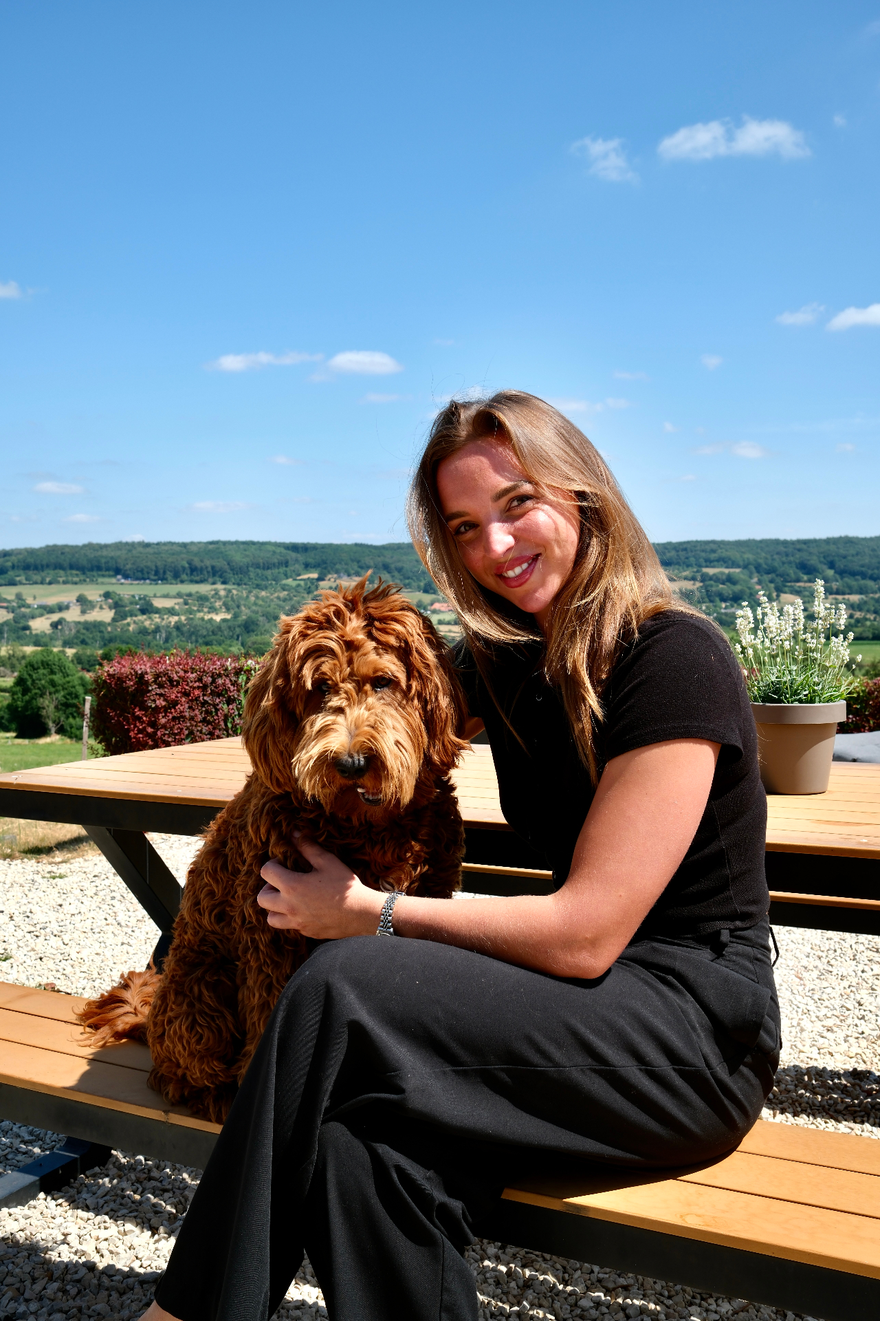 Nadine, eigenaar van Hoeve de Eik, met haar hond op het terras